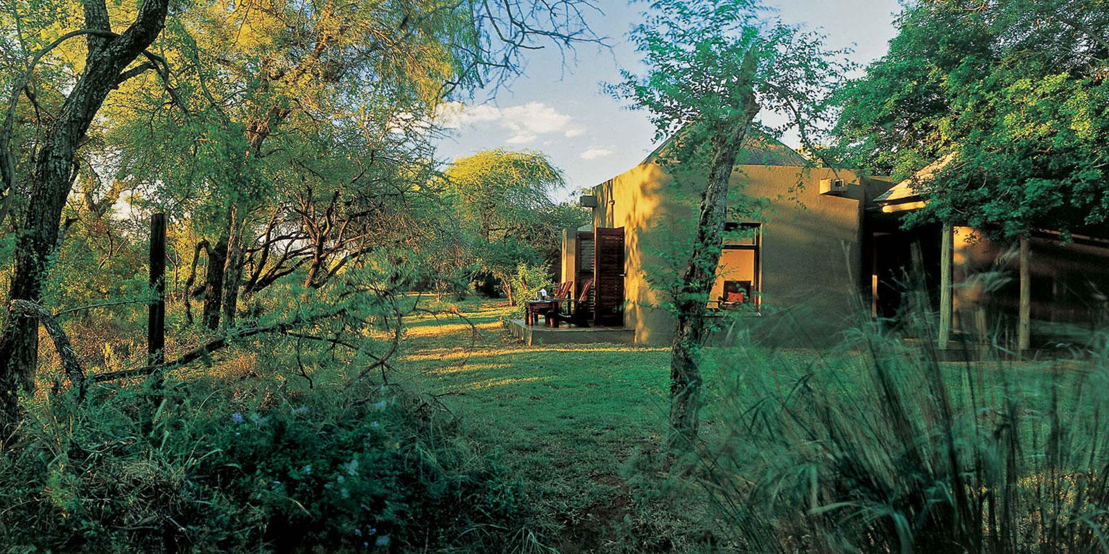 <p>The exterior of the Bush Lodge suites feature a blend of traditional African architecture and modern design, with thatched roofs, natural stone walls, and wooden decks that overlook the surrounding bushveld. The suites are nestled in a lush garden setting, and offer guests privacy and seclusion.</p>